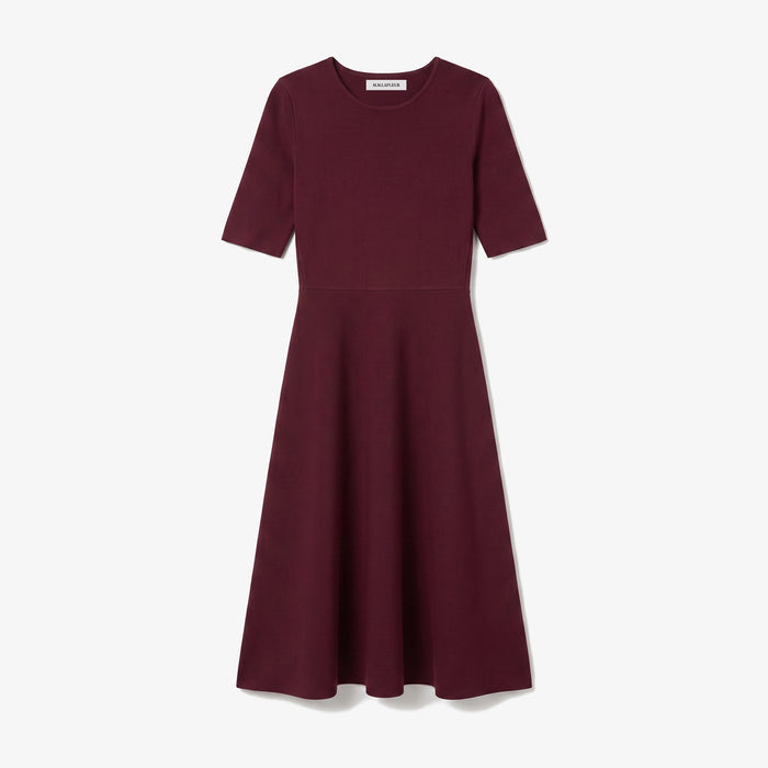 A short-sleeve A-line dress in deep burgundy, featuring a round neckline and a flared skirt, shown against a light gray background.